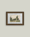 Framed artwork of a landscape with trees on a plain wall