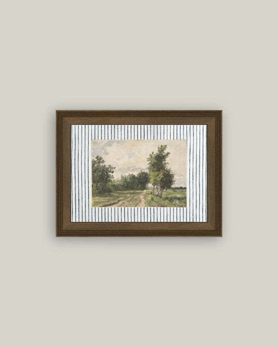 Framed artwork of a landscape with trees on a plain wall